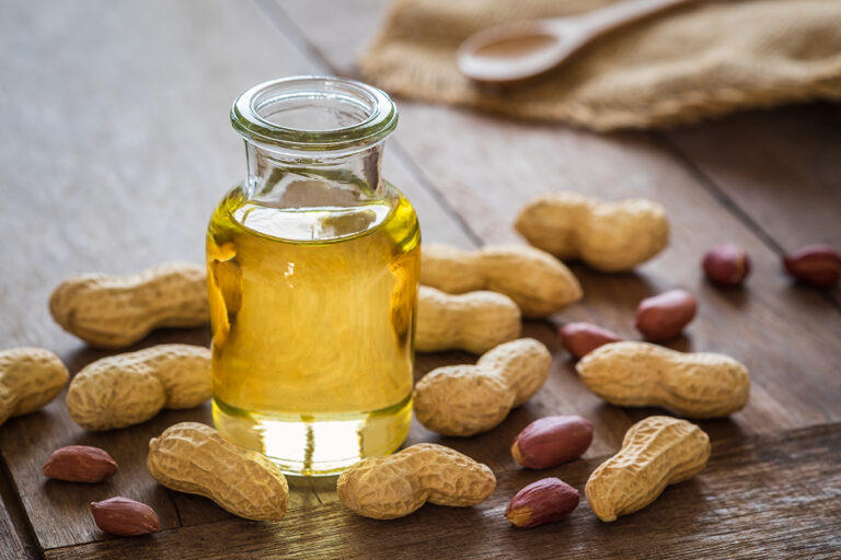 a bottle of groundnut oil next to peanuts.